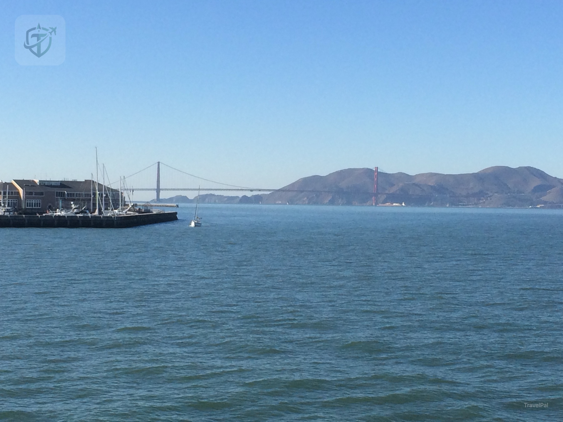Alcatraz Island and the San Francisco Bay viewed from the ferry, with the Golden Gate Bridge in the distance