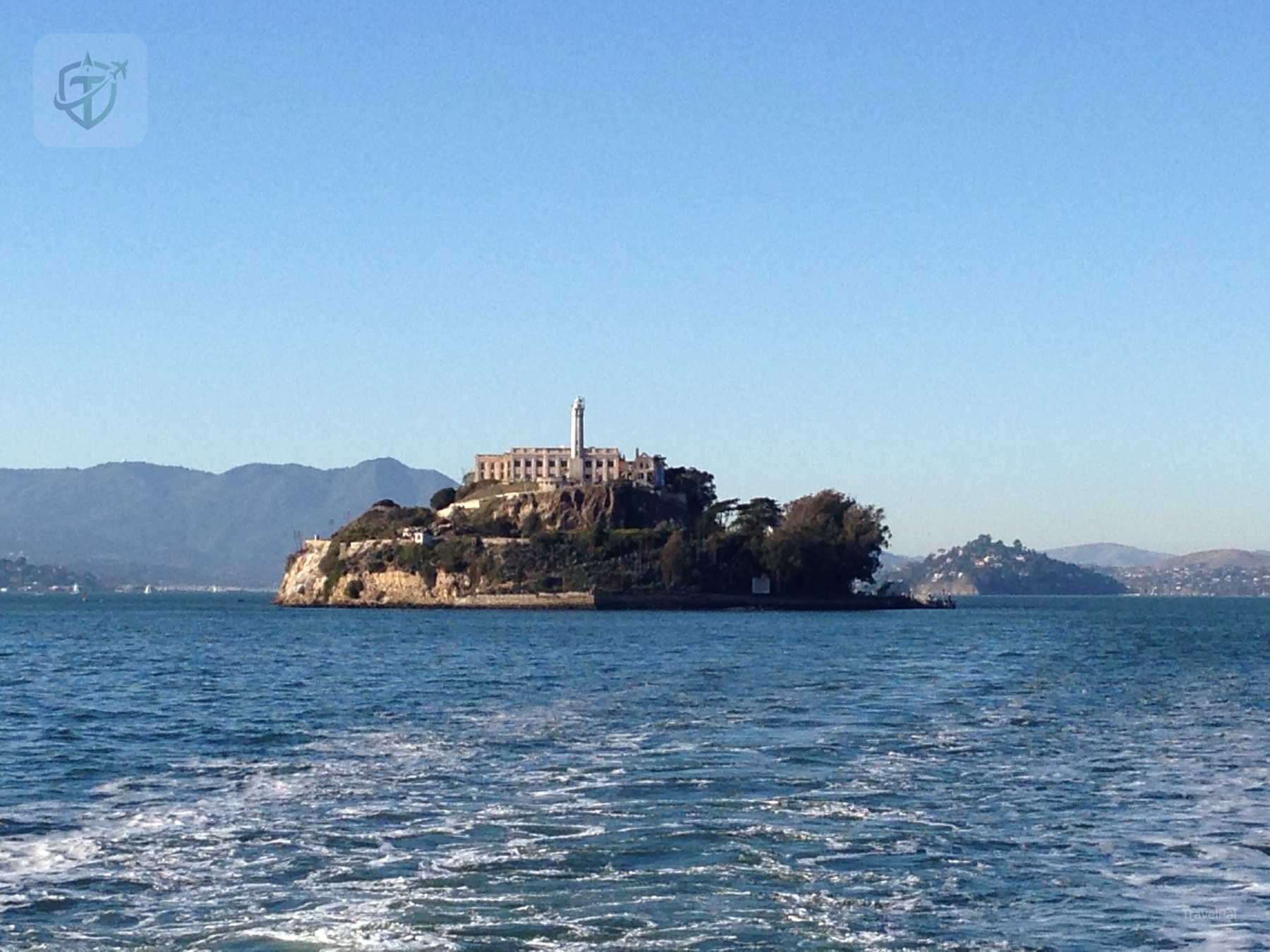 Alcatraz Island seen from the water with the cellhouse and San Francisco Bay behind it
