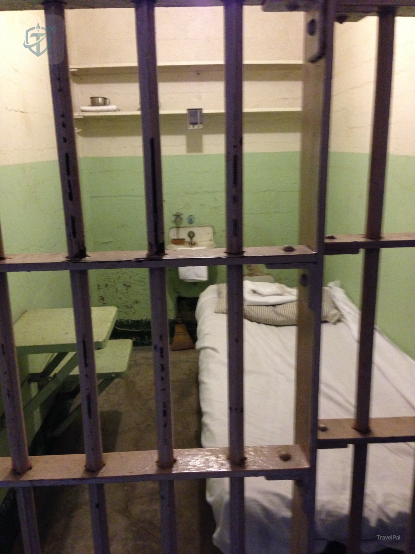 Alcatraz cell bunk, sink, and toilet behind metal bars