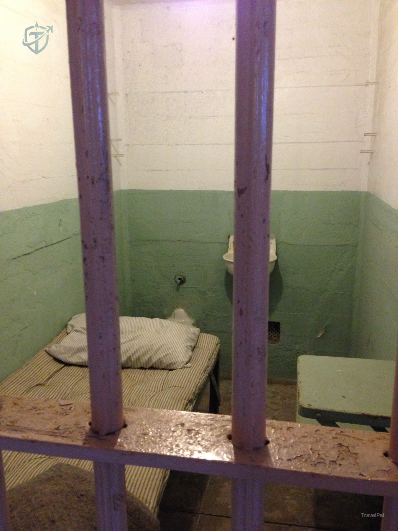 Alcatraz cell interior viewed through purple-painted bars
