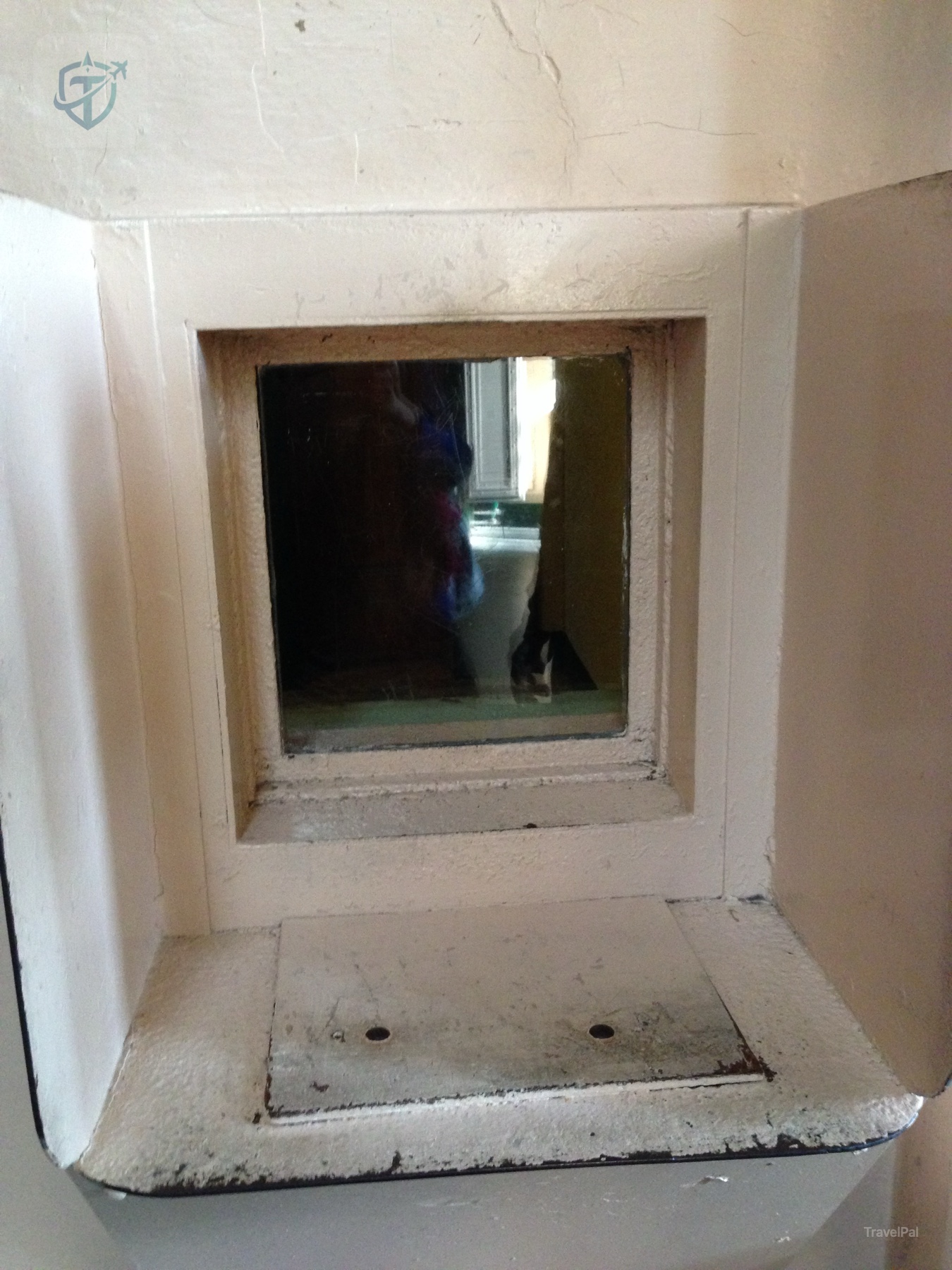 Small square opening in a worn Alcatraz wall