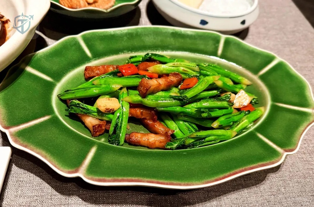 Green ceramic platter with vegetables and sliced meat at Alila Shanghai