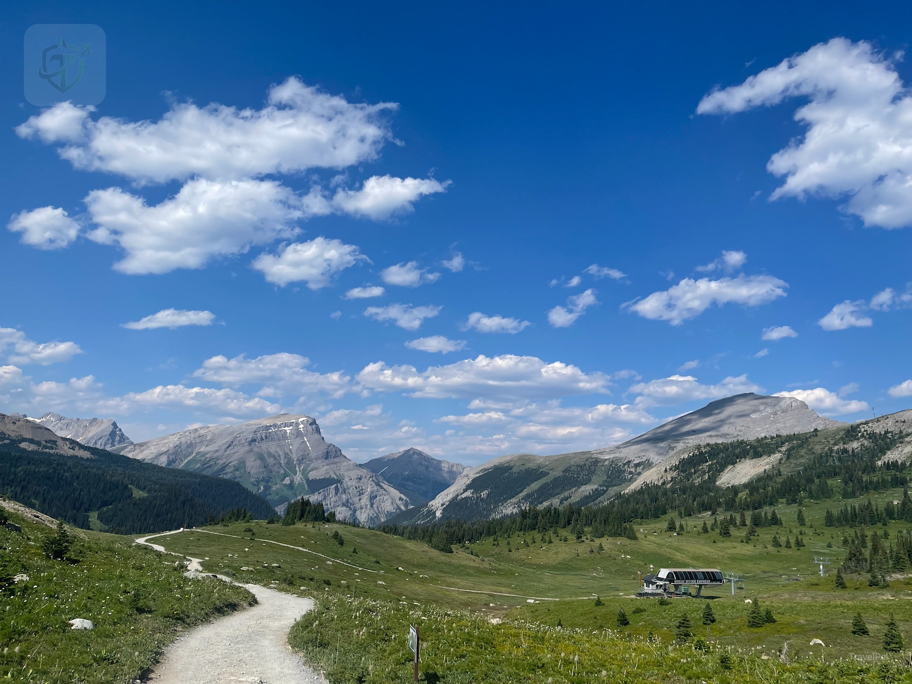 A walking path across Sunshine Meadows with the gondola station below and mountains beyond