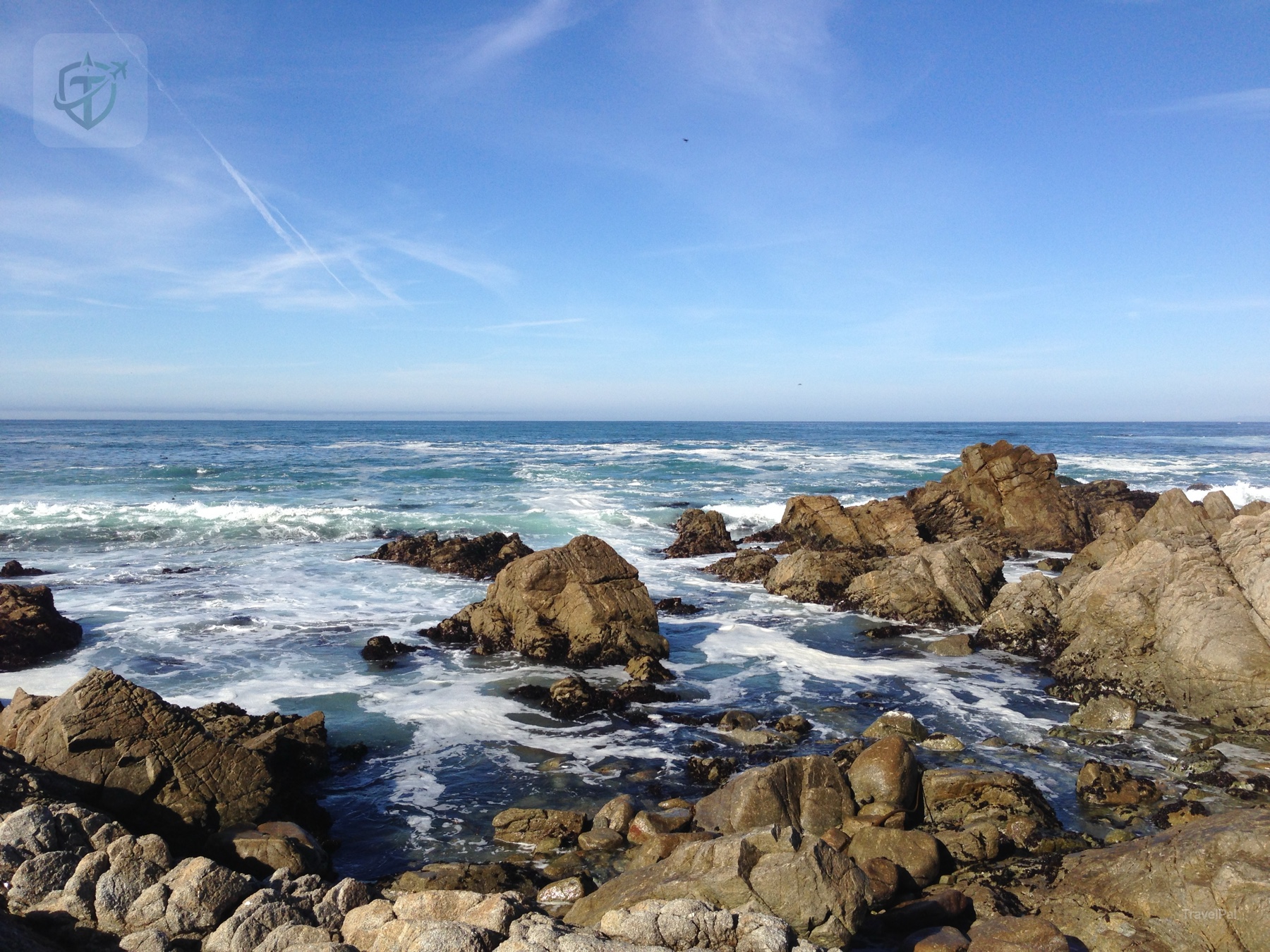 Angular brown rocks and bright surf at a California coastal viewpoint