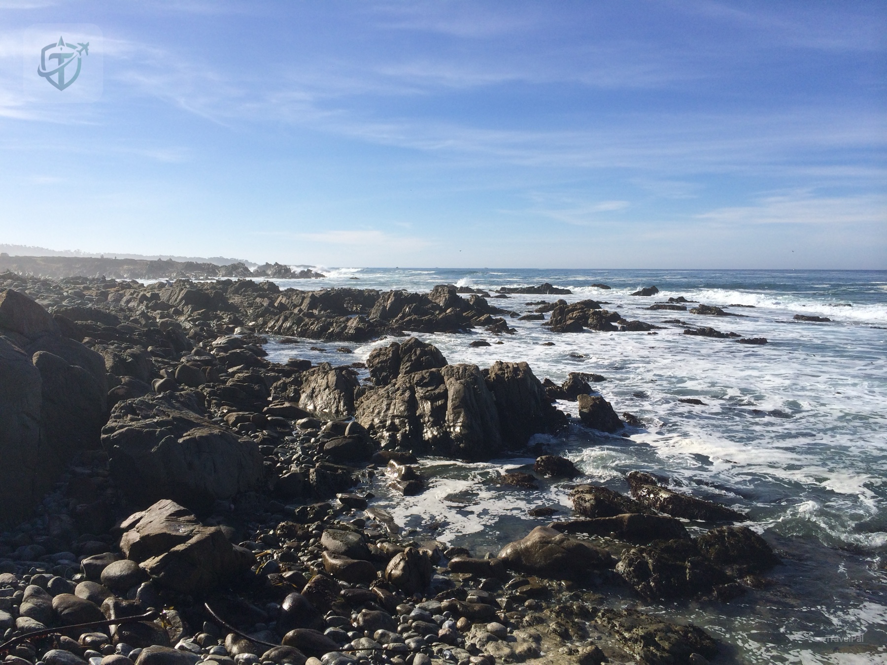 White surf breaking over a rocky shoreline on California Highway 1