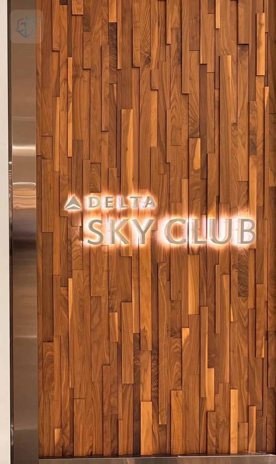Illuminated Delta Sky Club sign on a textured wood wall at MSP