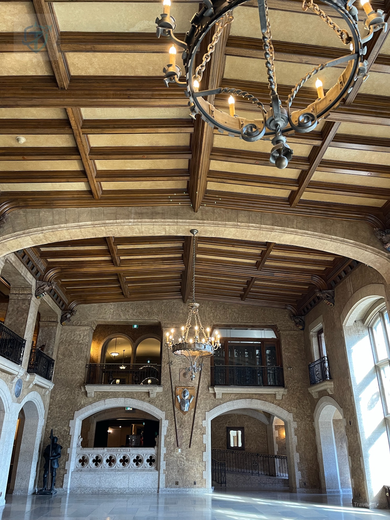 Close view of an iron ring chandelier beneath the carved wood ceiling of Fairmont Banff Springs