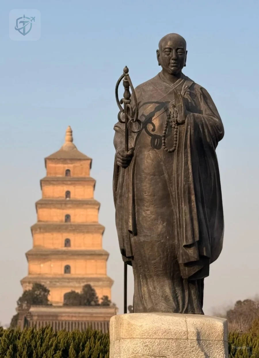 Statue of Buddhist monk Xuanzang with Giant Wild Goose Pagoda in warm afternoon light