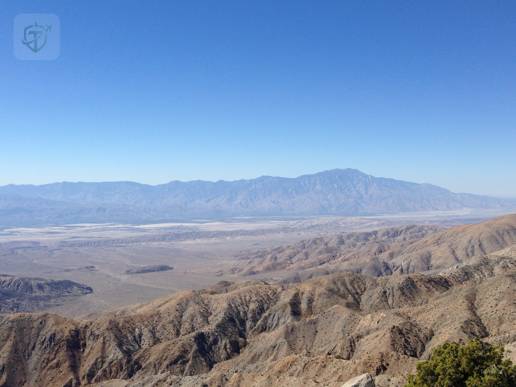 Wide desert basin and layered mountain ranges seen from a high overlook in Joshua Tree National Park