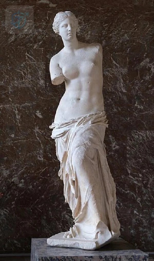 Venus de Milo displayed against dark stone at the Louvre