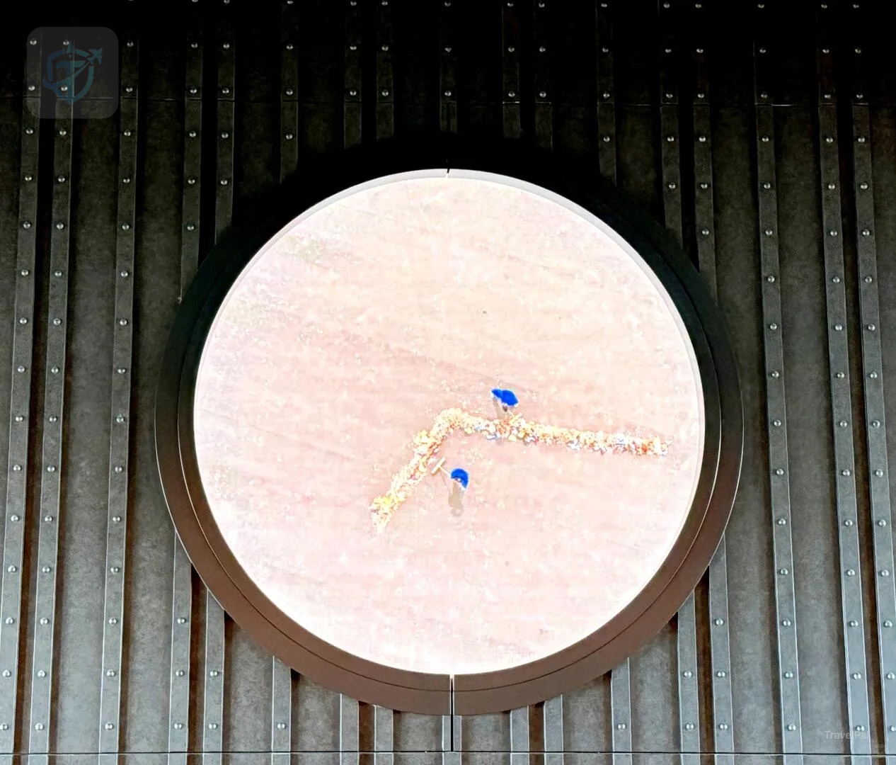 Large circular clock set into a dark wall at The Osaka Station Hotel
