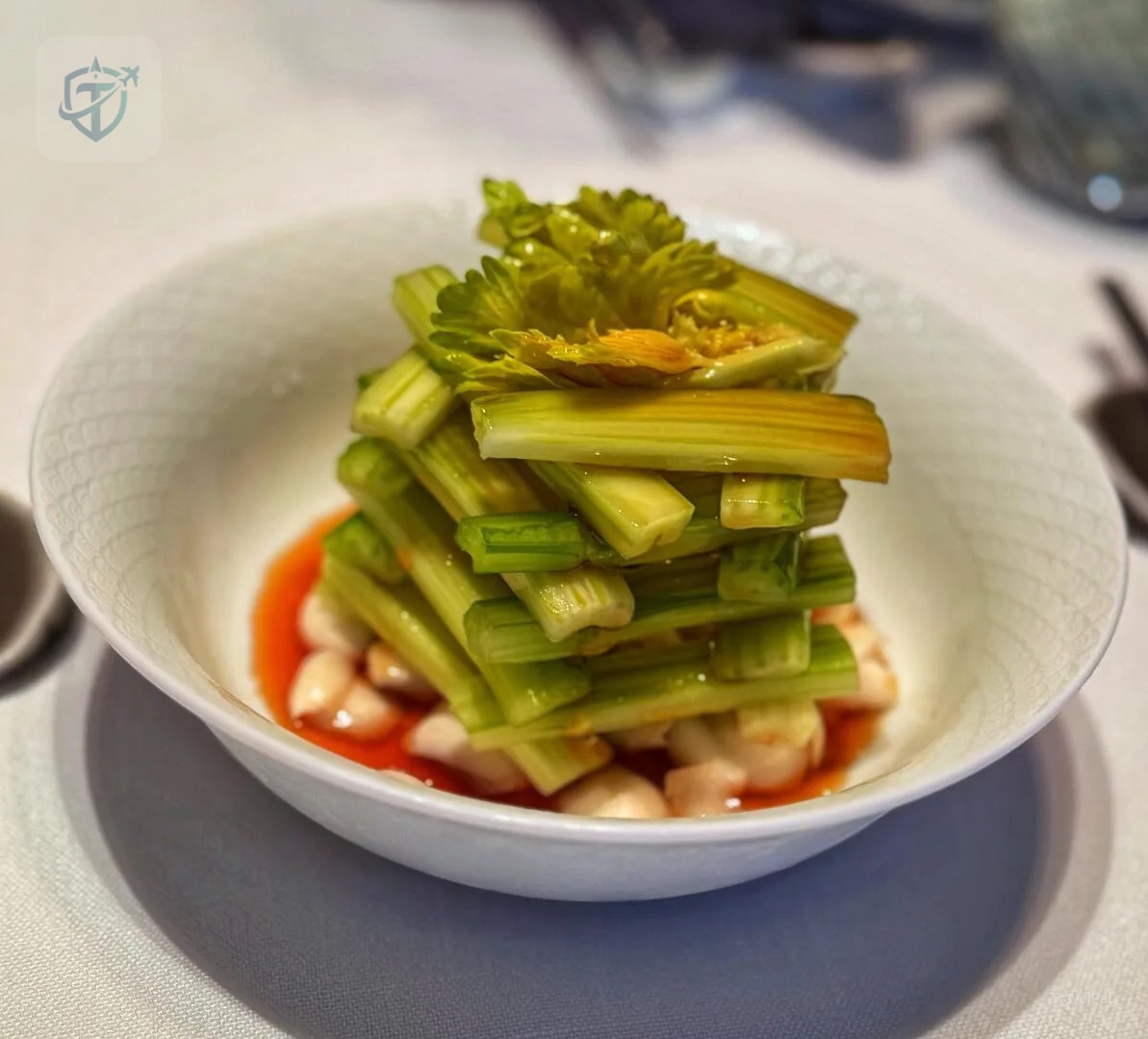 Neatly stacked celery served over a red sauce at Dining Room