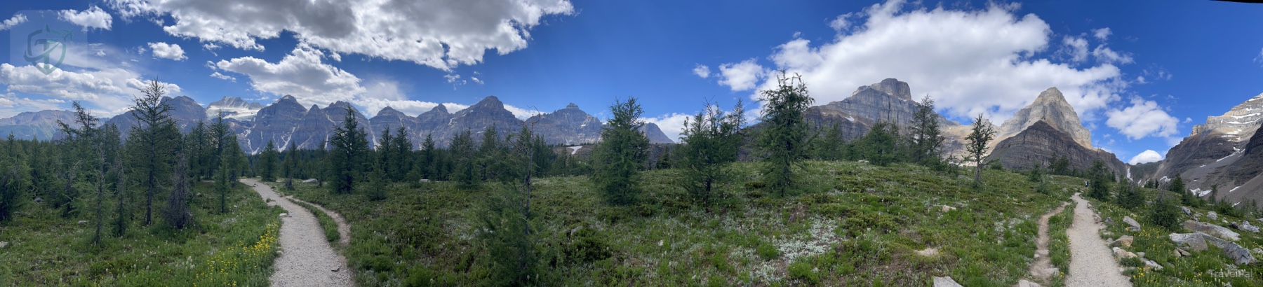 Open alpine valley surrounded by jagged snow-streaked peaks on the Sentinel Pass route