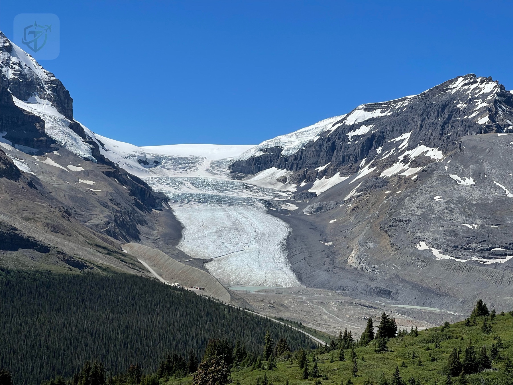 Glacier and snowfields between dark mountain slopes beside the Wilcox Pass trail