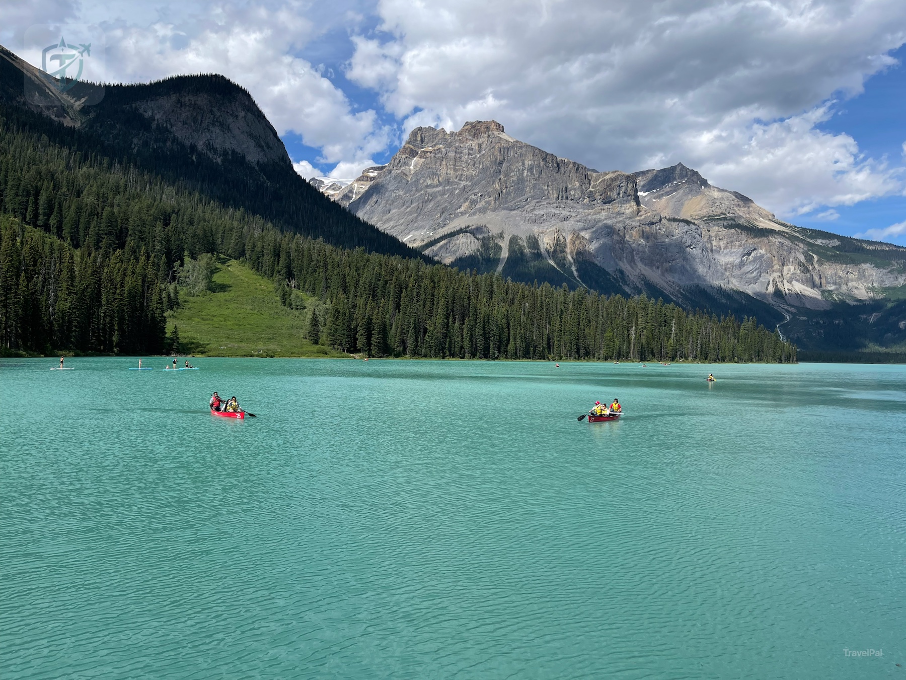 Emerald Lake in Yoho National Park with canoes on turquoise water and forested mountains behind